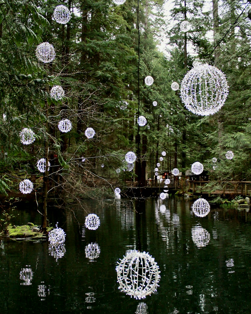a pond filled with lots of white balls floating in the air