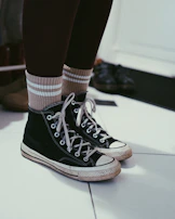 a pair of black and white shoes with striped socks