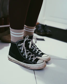 a pair of black and white shoes with striped socks