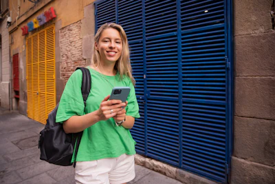 a woman in a green shirt is looking at her cell phone