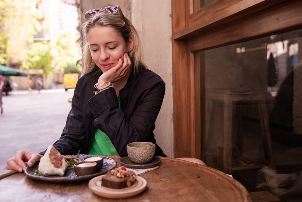 a woman sitting at a table with a plate of food