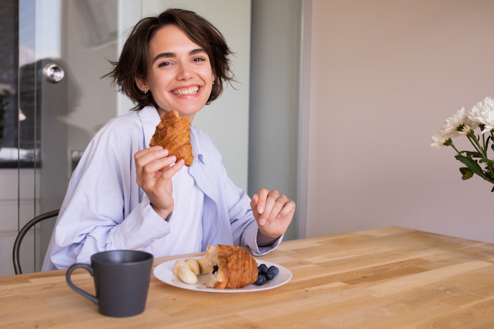 a woman sitting at a table with a plate of food