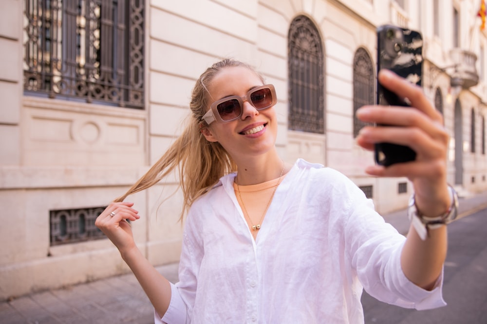 eine Frau, die ein Selfie mit ihrem Handy macht