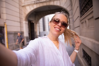 a woman is smiling and holding her hair in her hand