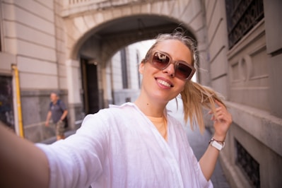 a woman is smiling and holding her hair in her hand