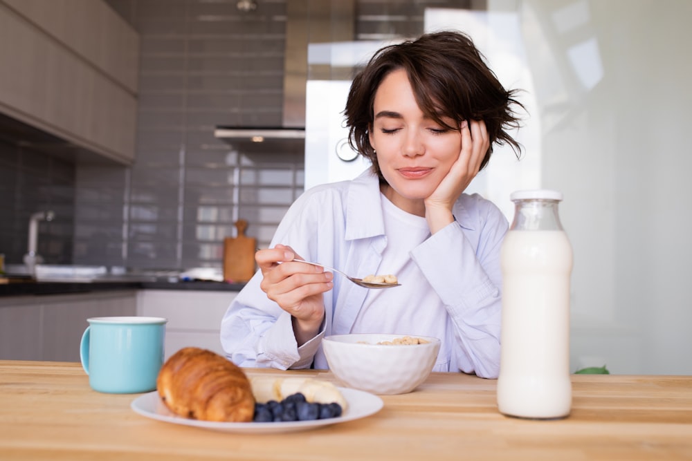 a woman sitting at a table with a plate of food