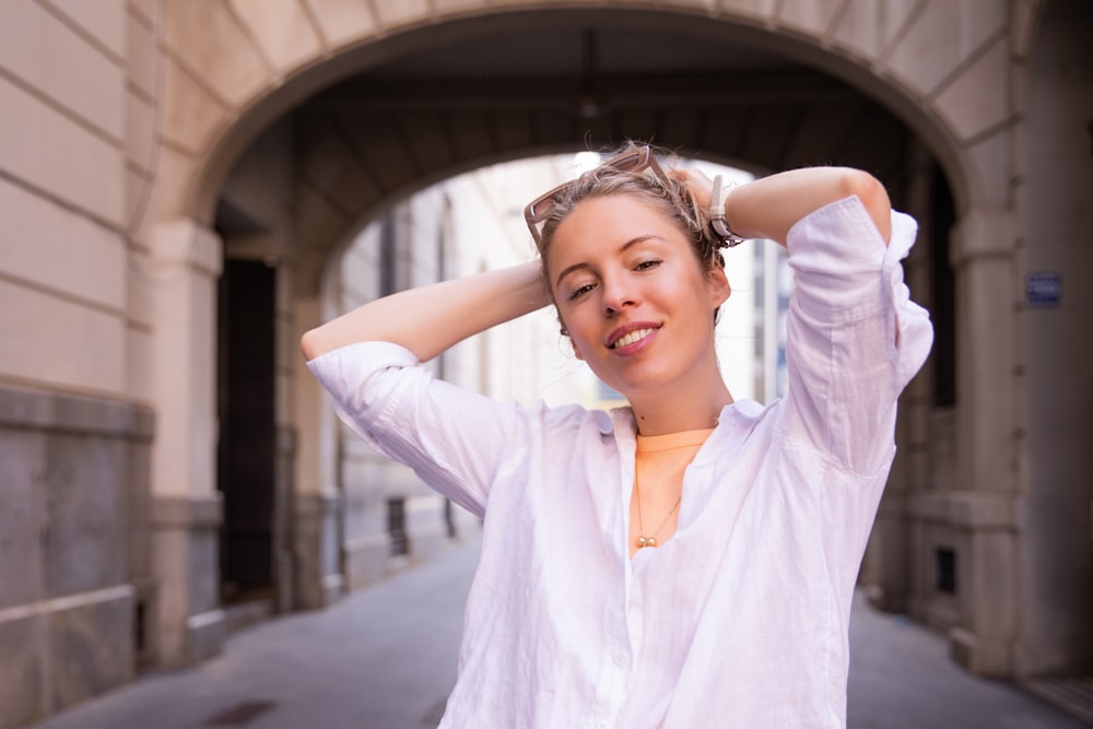 Une femme en chemise blanche se tient la tête