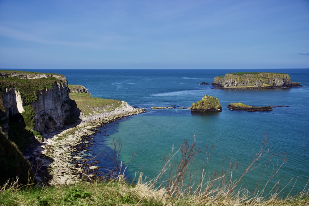 a large body of water surrounded by a lush green hillside