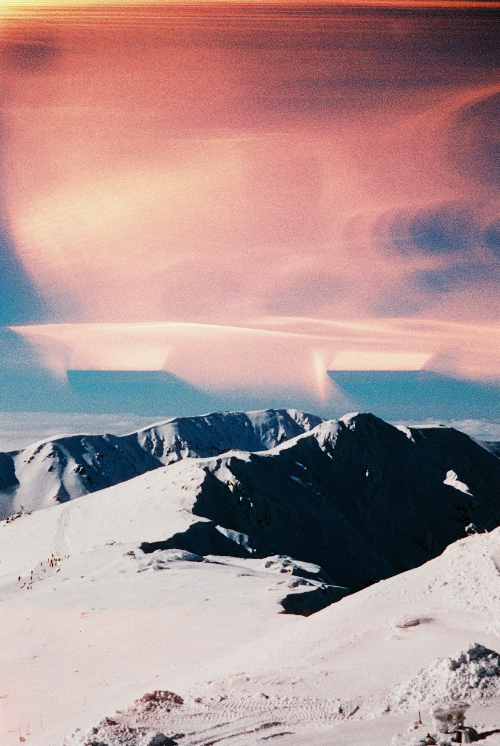 a person on a snowboard on top of a snow covered mountain