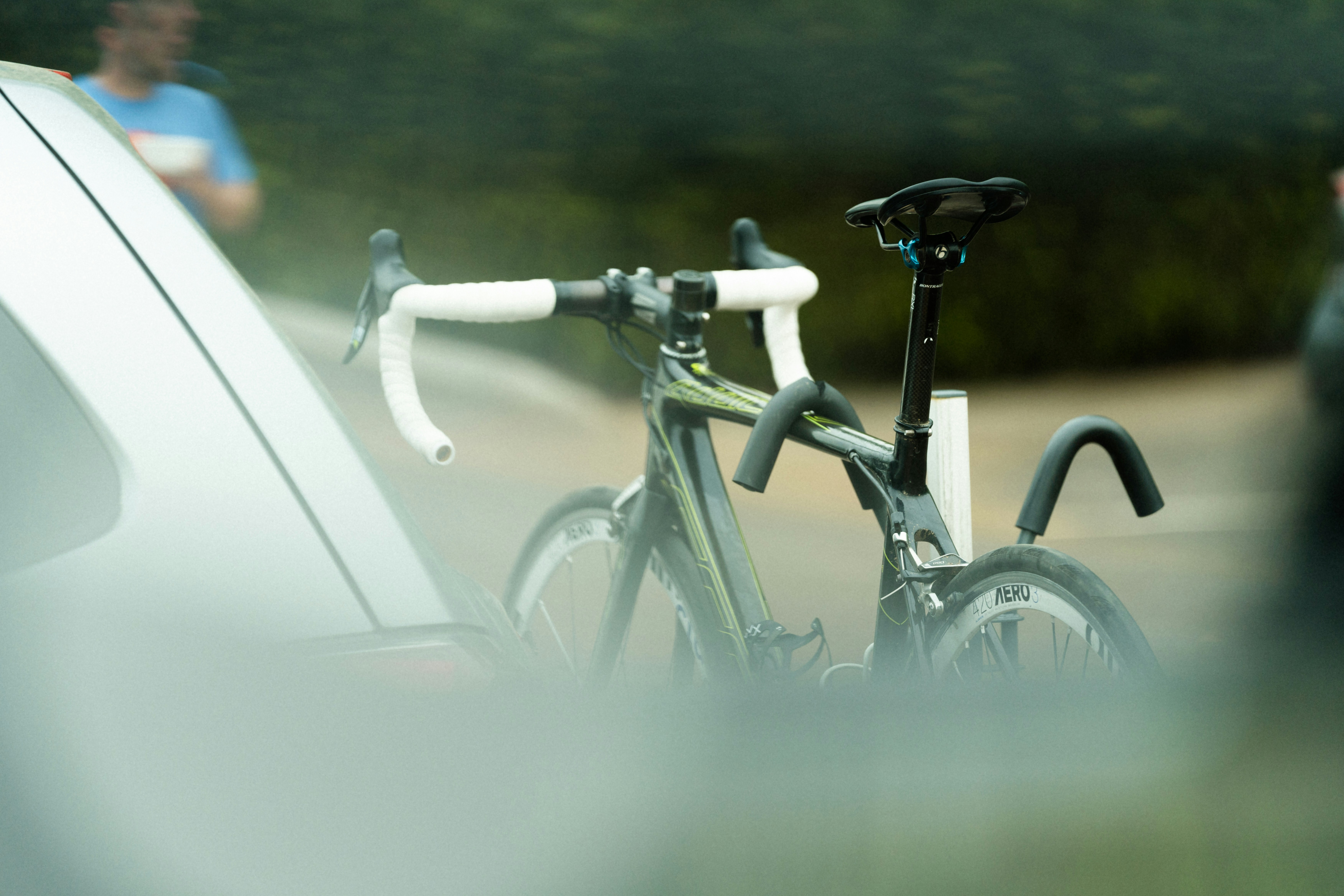 a bicycle parked next to a car on the side of the road