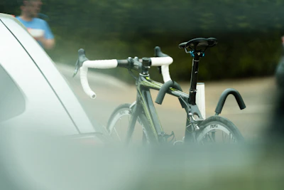 a bicycle parked next to a car on the side of the road