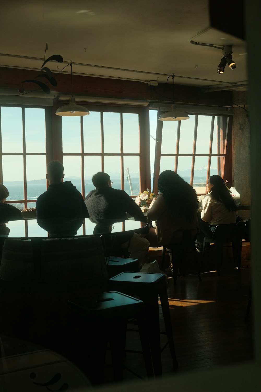a group of people sitting at a table in front of a window