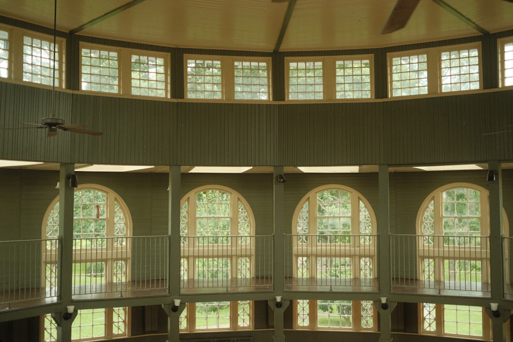 a large room with several windows and a ceiling fan