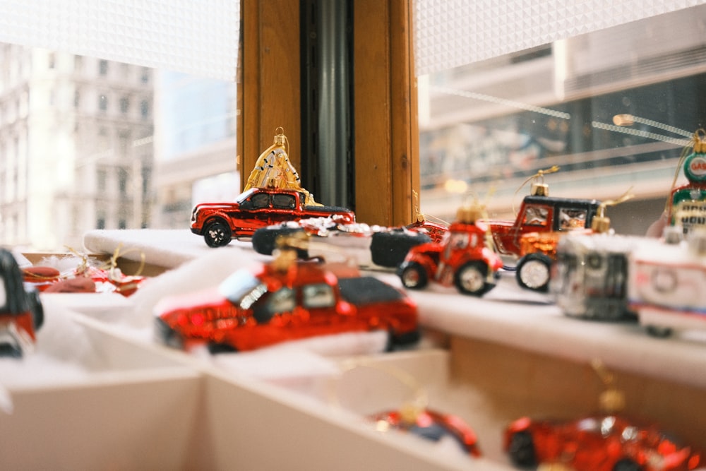 a bunch of toy cars sitting on a window sill