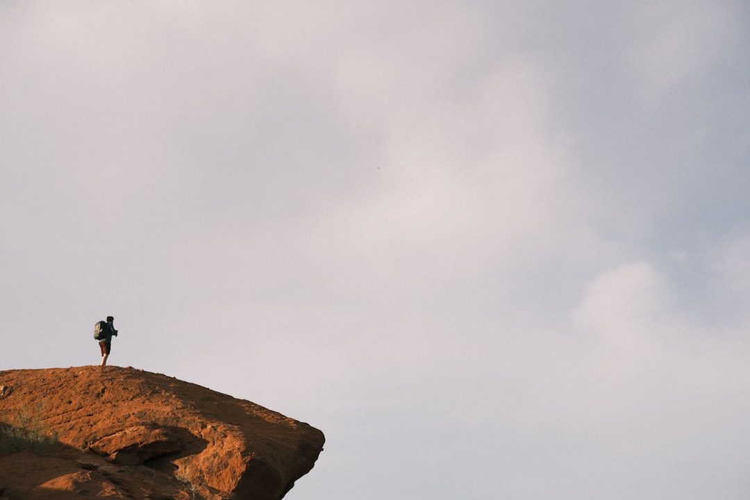 a person standing on top of a cliff,