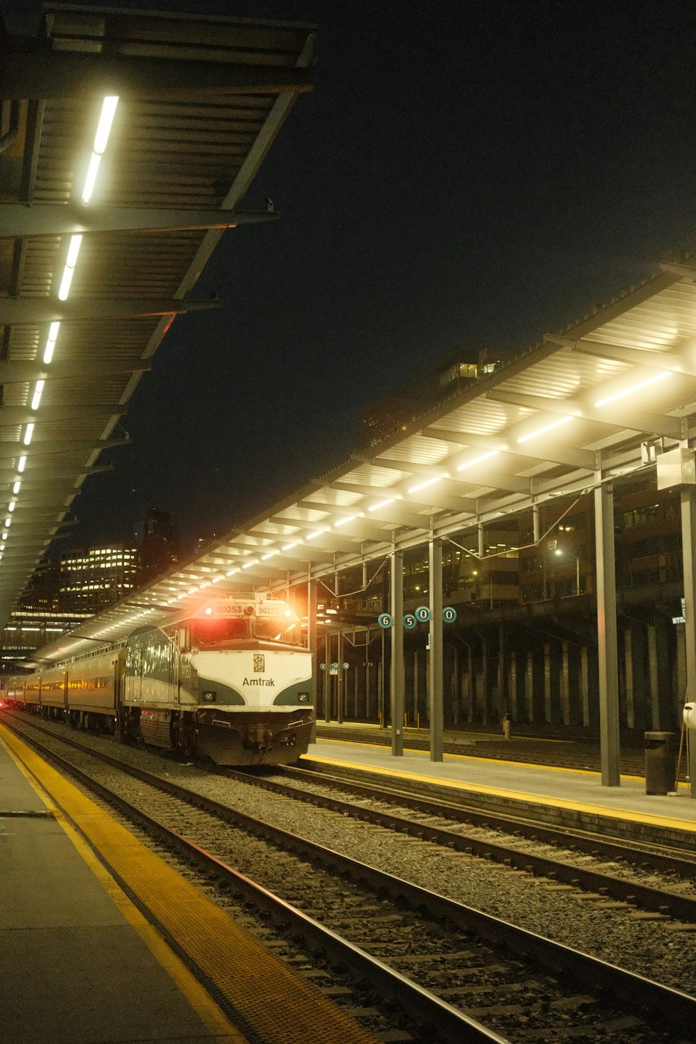 a train pulling into a train station at night