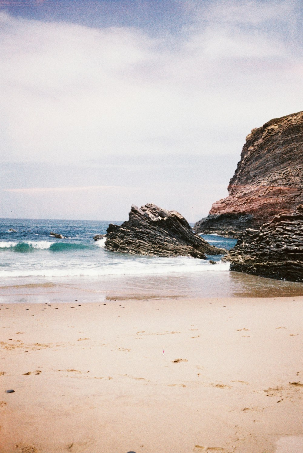 a person walking on a beach with a surfboard