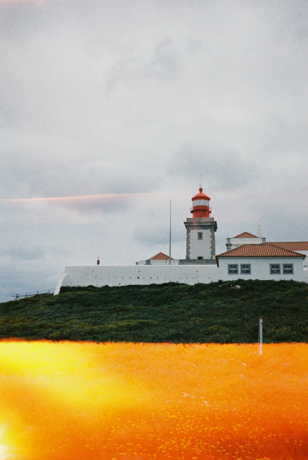 a lighthouse on top of a grassy hill