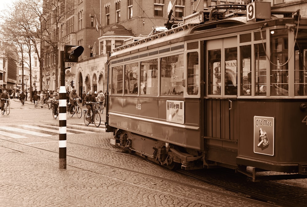 a trolley car on a city street with people riding bikes