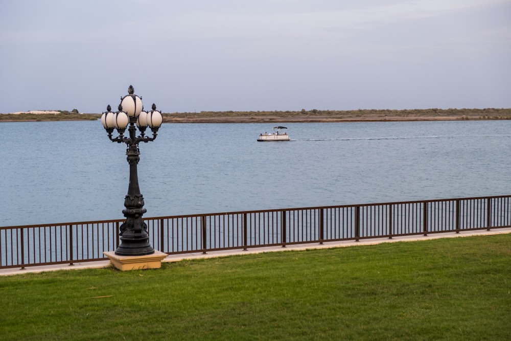 a lamp post in front of a body of water