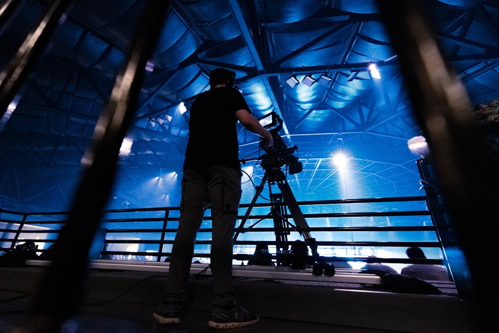 a man standing in front of a camera on a tripod