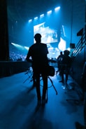 a man standing in front of a stage with a guitar