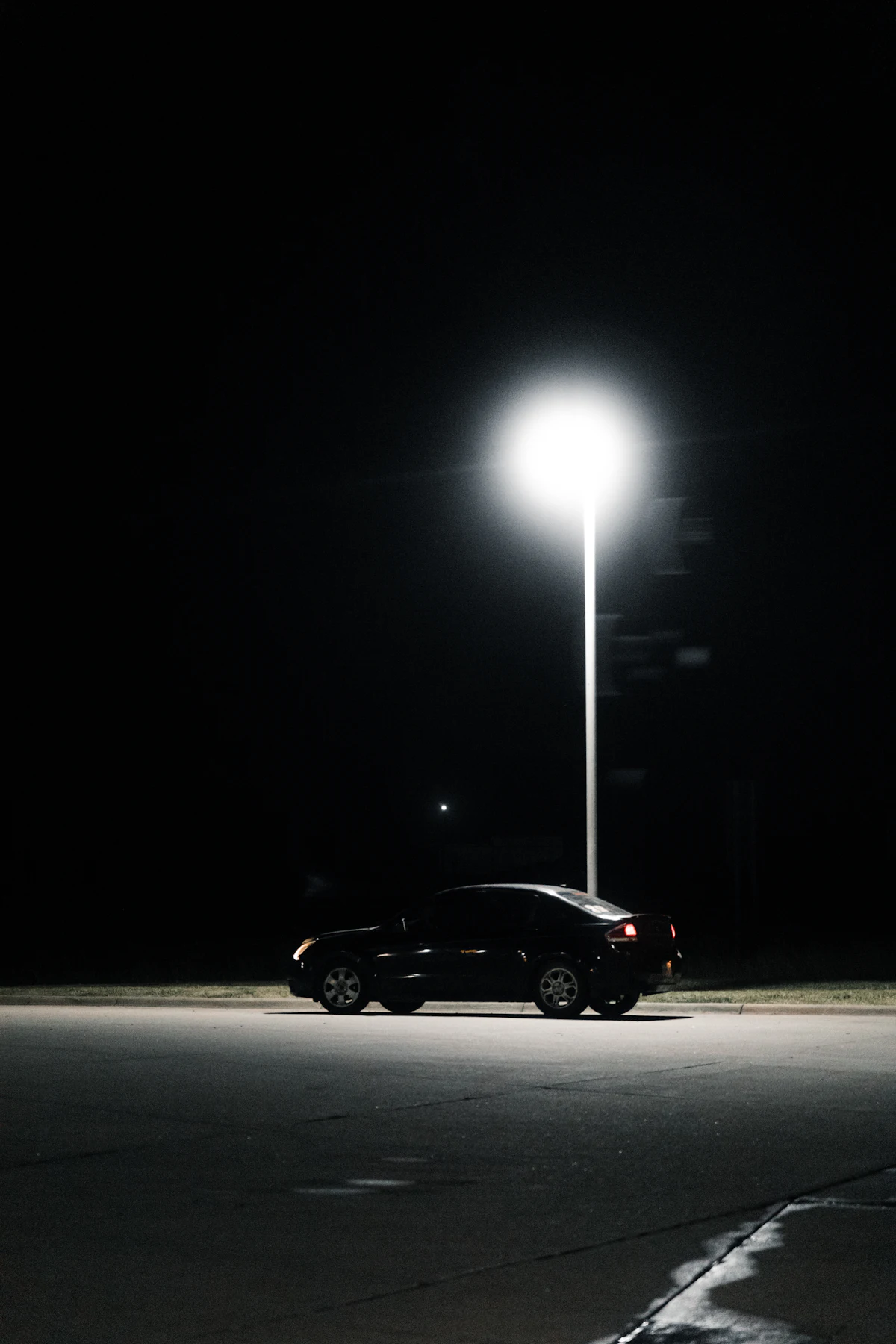 A car parked alone in a lot at night