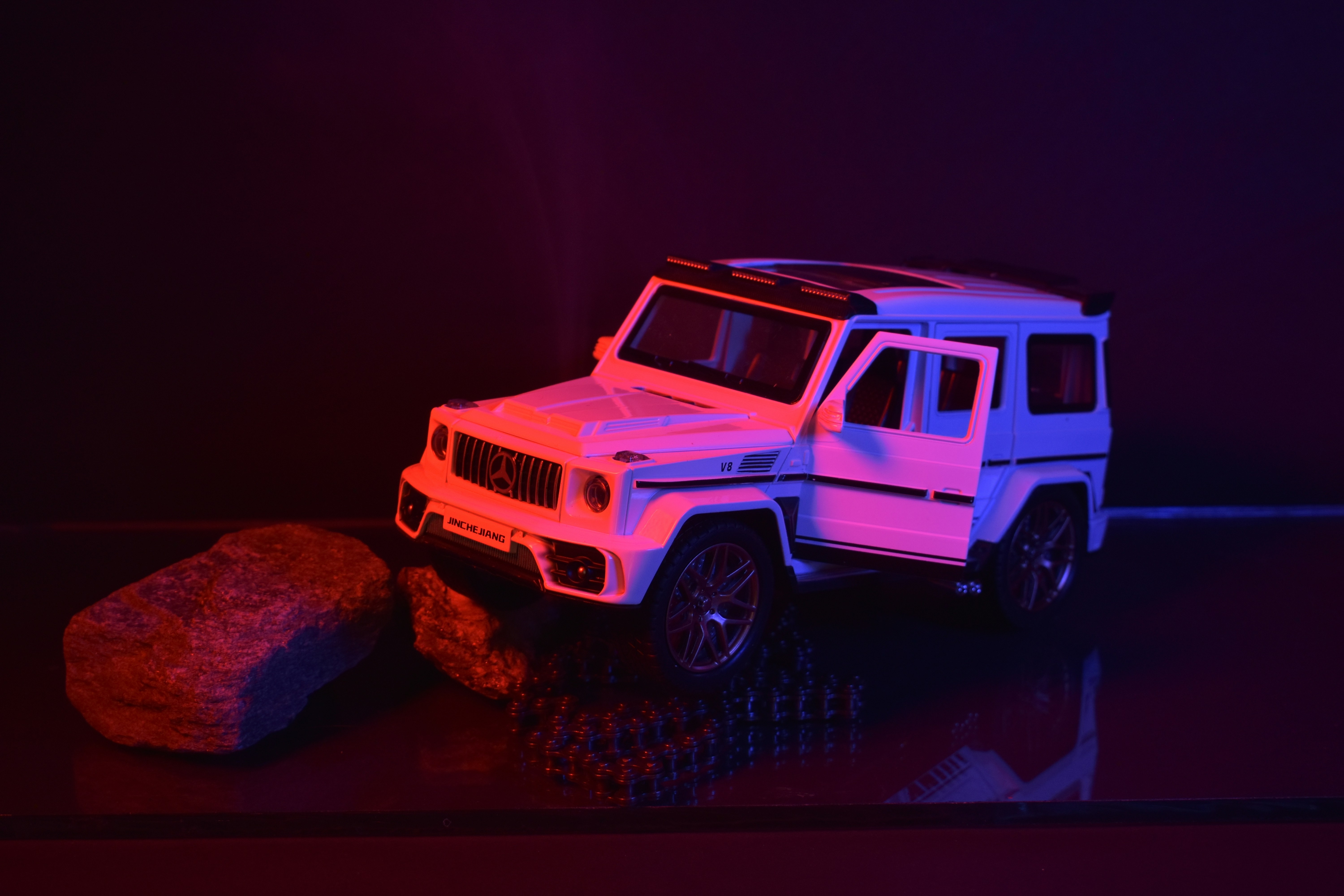 a toy jeep is parked next to a rock