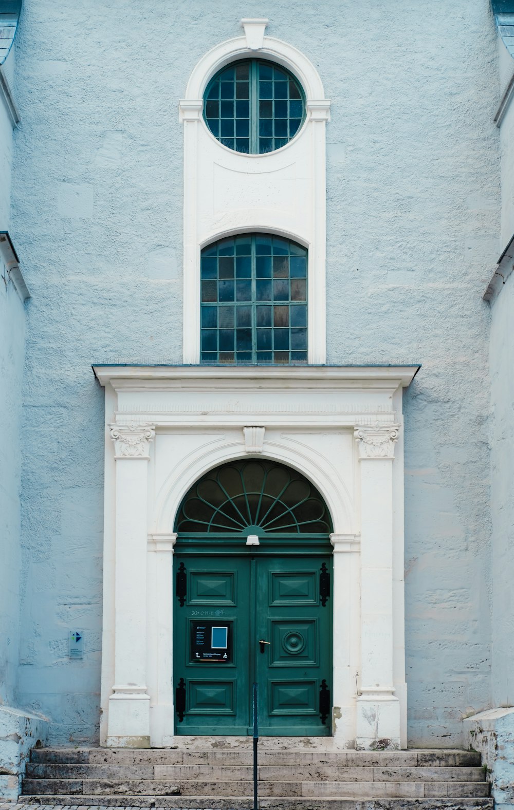 a building with a green door and a clock tower