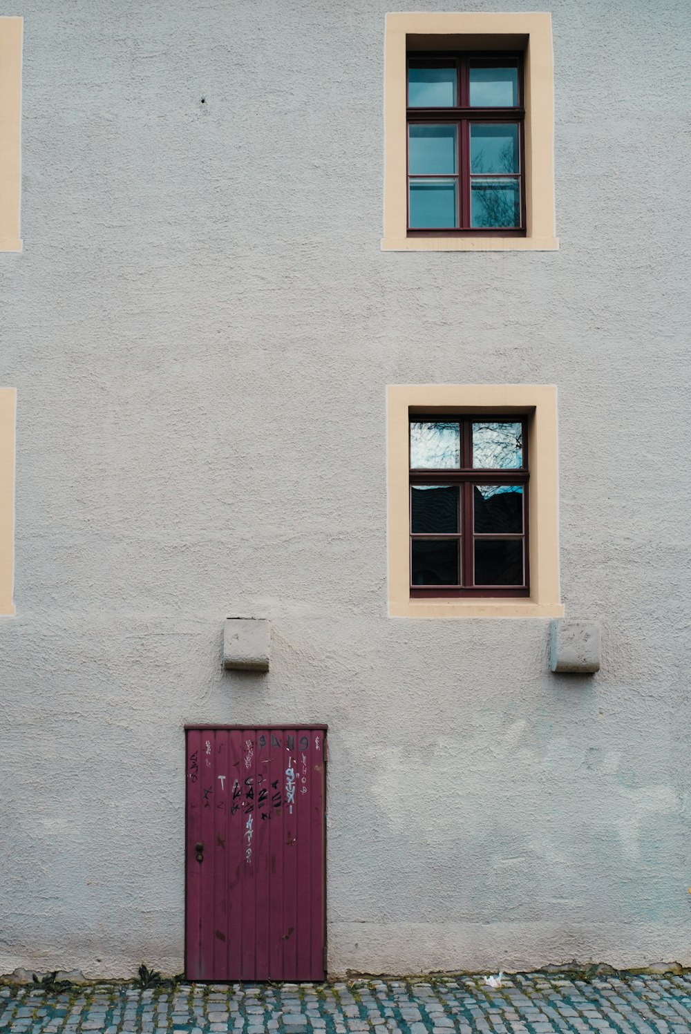 a red door sitting in front of a white building