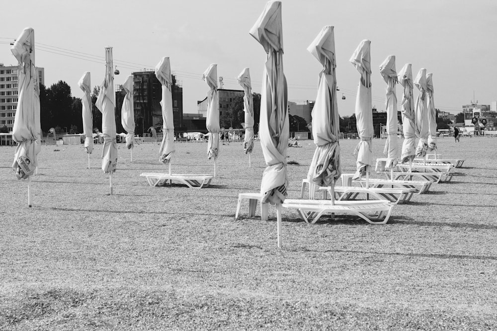 a black and white photo of beach chairs and umbrellas