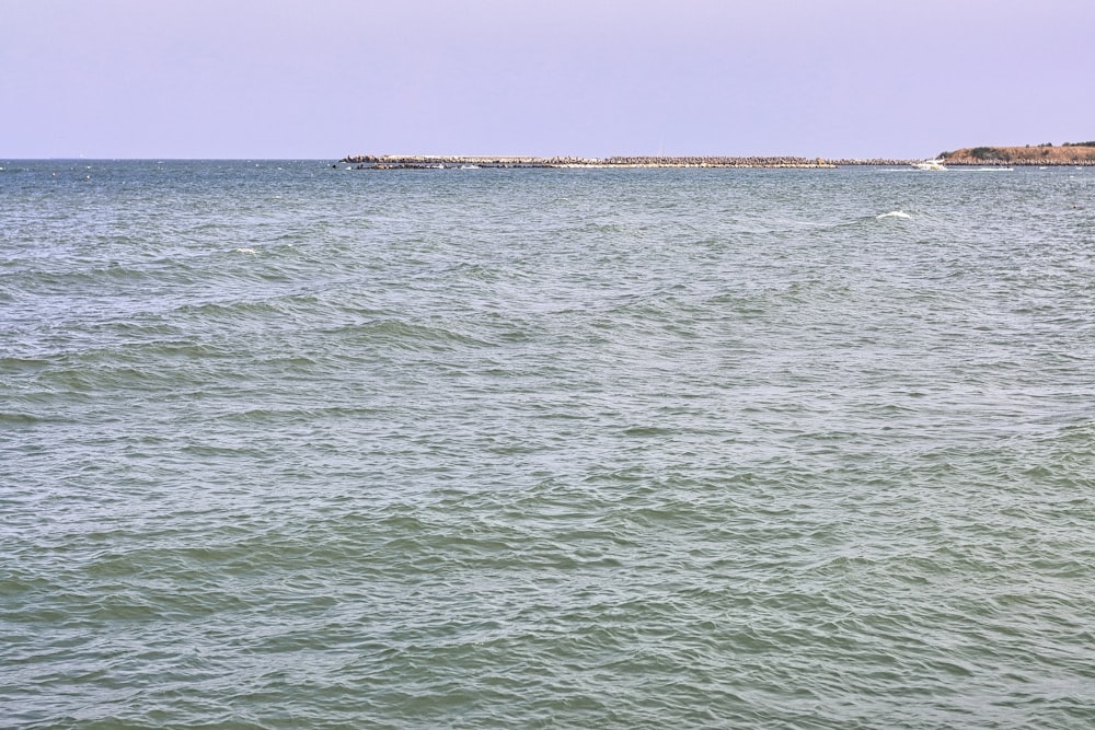 ein großes Gewässer mit einer kleinen Insel in der Ferne