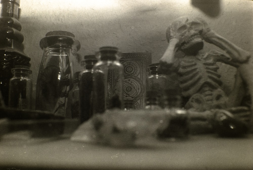 a black and white photo of bottles and jars