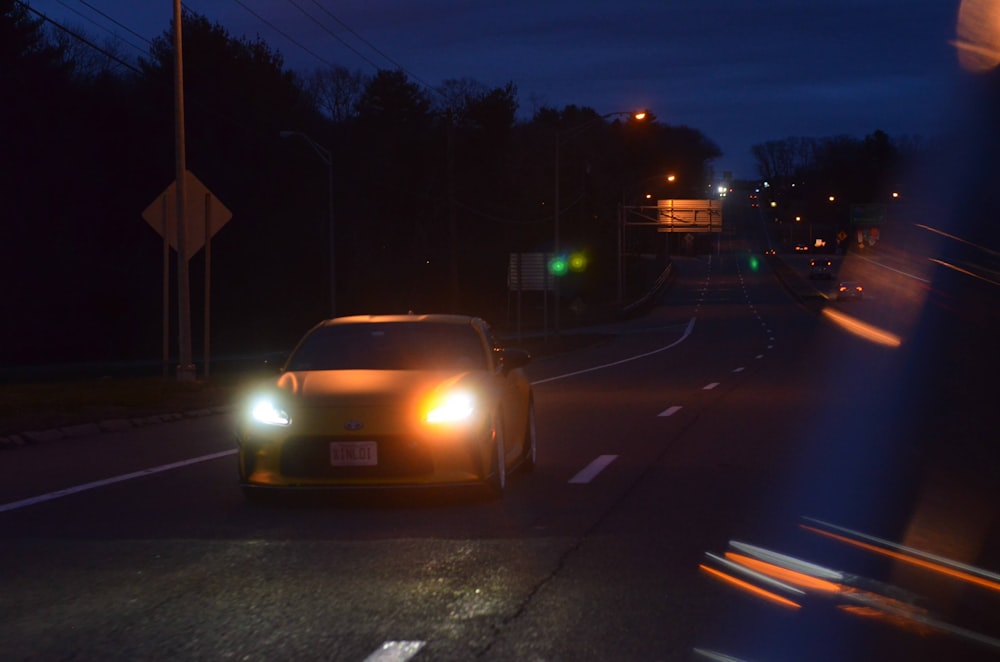 a car driving down a street at night