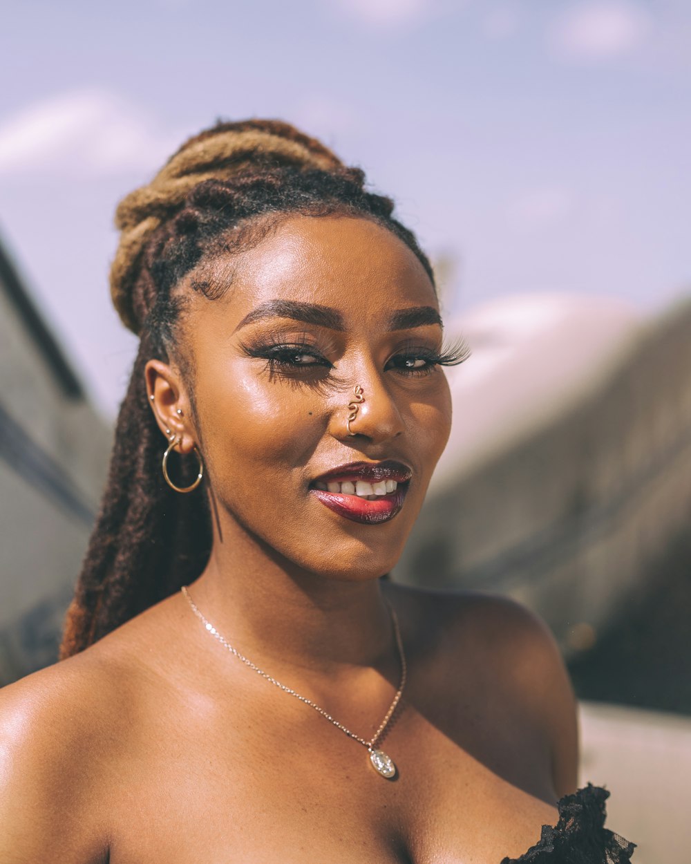 a woman in a black dress with a nose ring