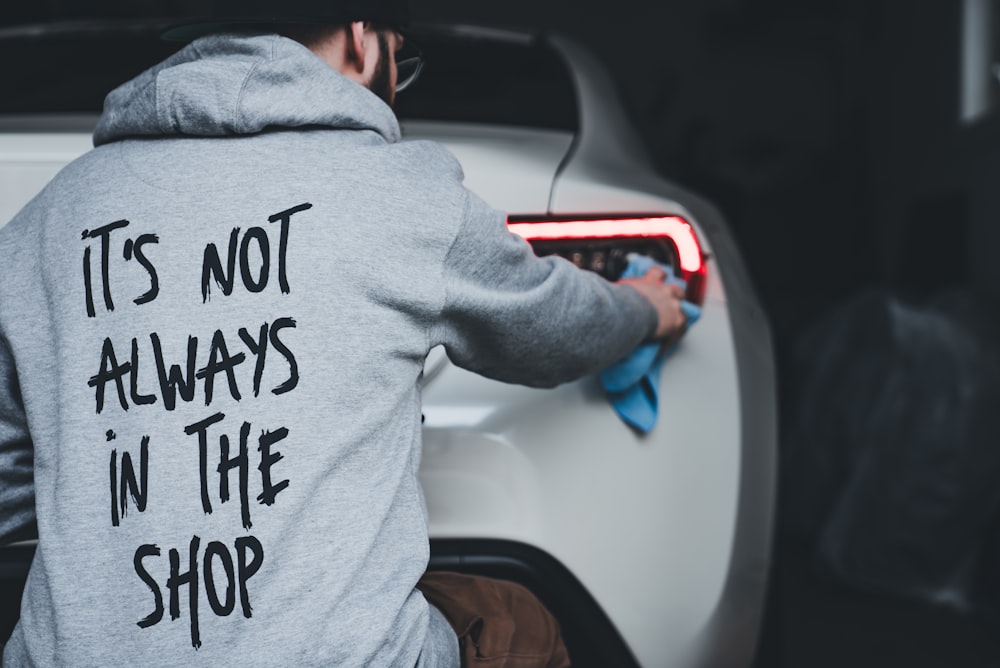 a man cleaning a car with a cloth