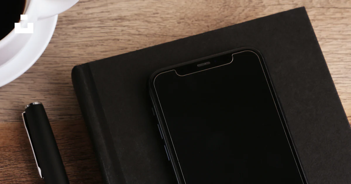 A notepad, pen, and cell phone on a desk photo – Free Black Image on ...