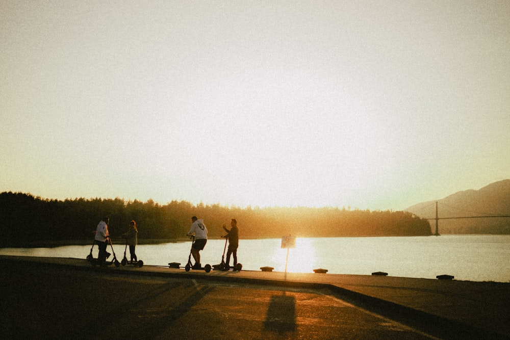 a group of people standing next to a body of water