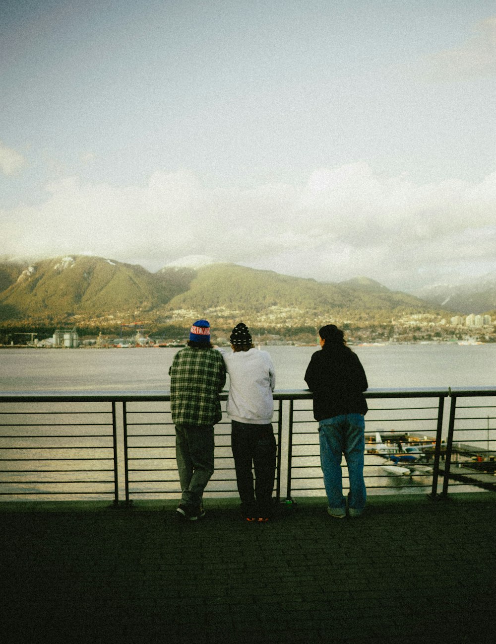 three people looking out over a body of water