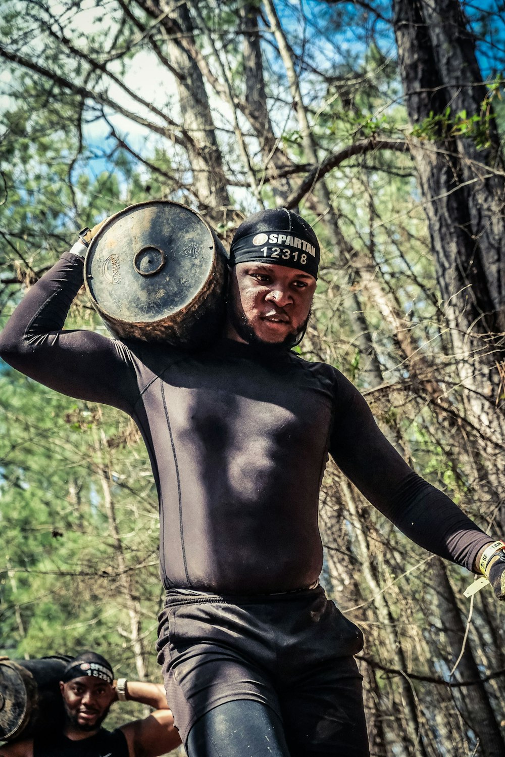 a man in a wet suit carrying a large drum