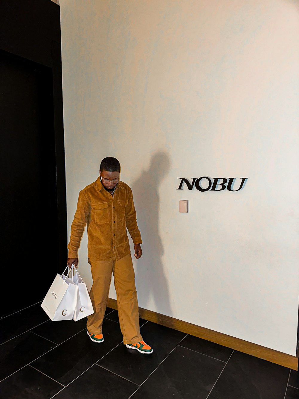 a man in an orange jumpsuit holding shopping bags