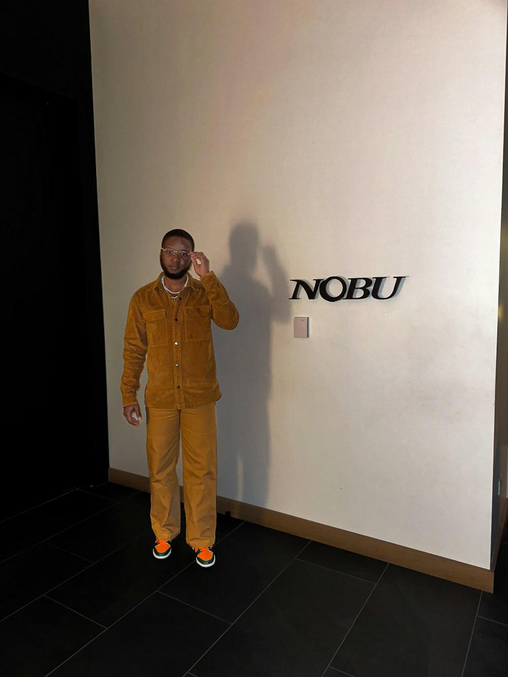 a man standing in front of a nobu sign