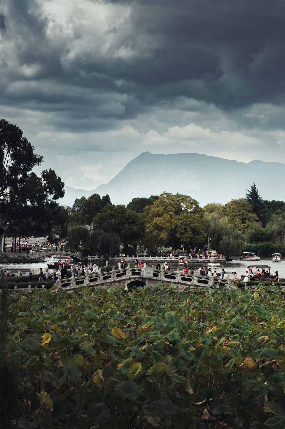 a group of people walking across a bridge over a river