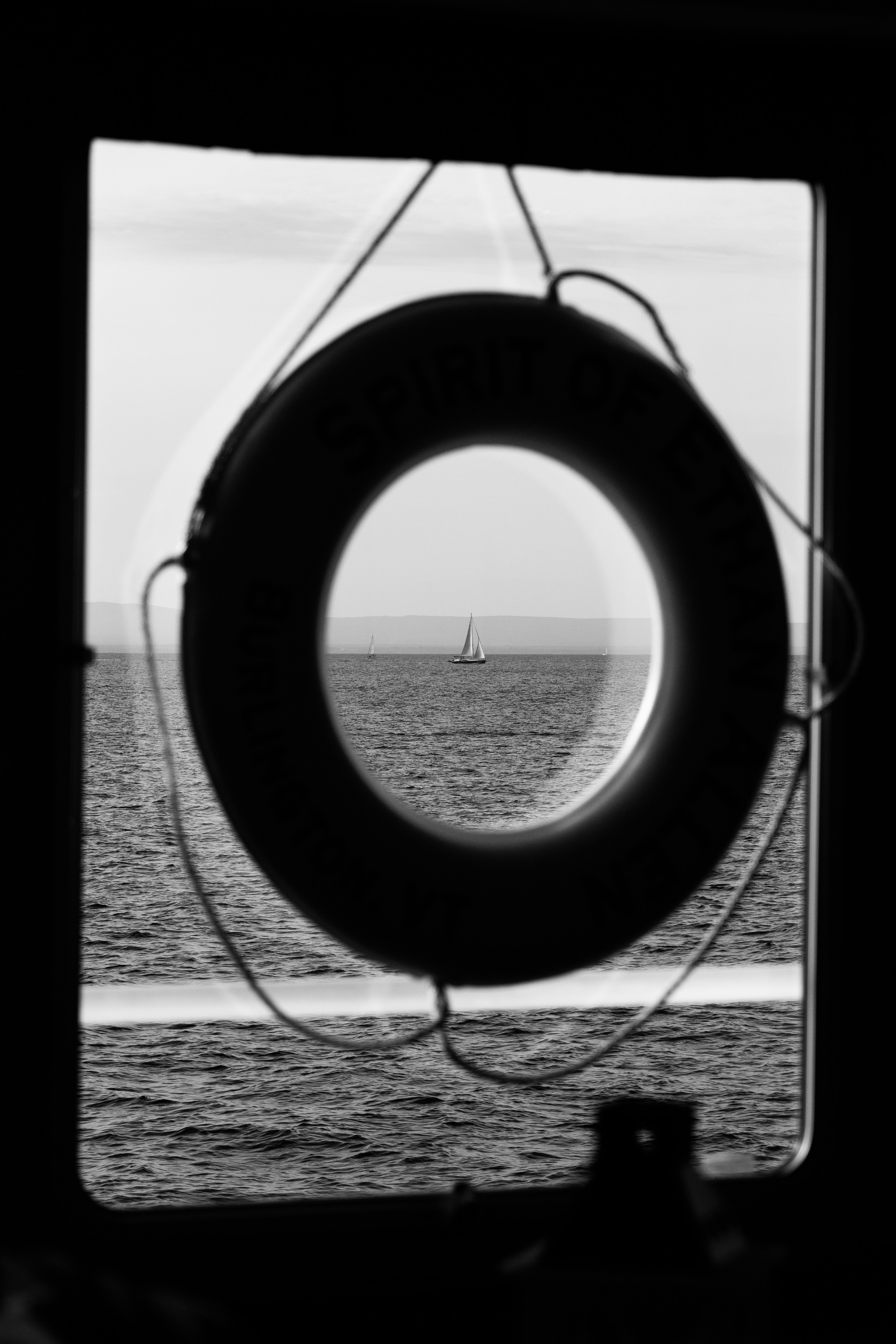 a black and white photo of a boat in the ocean