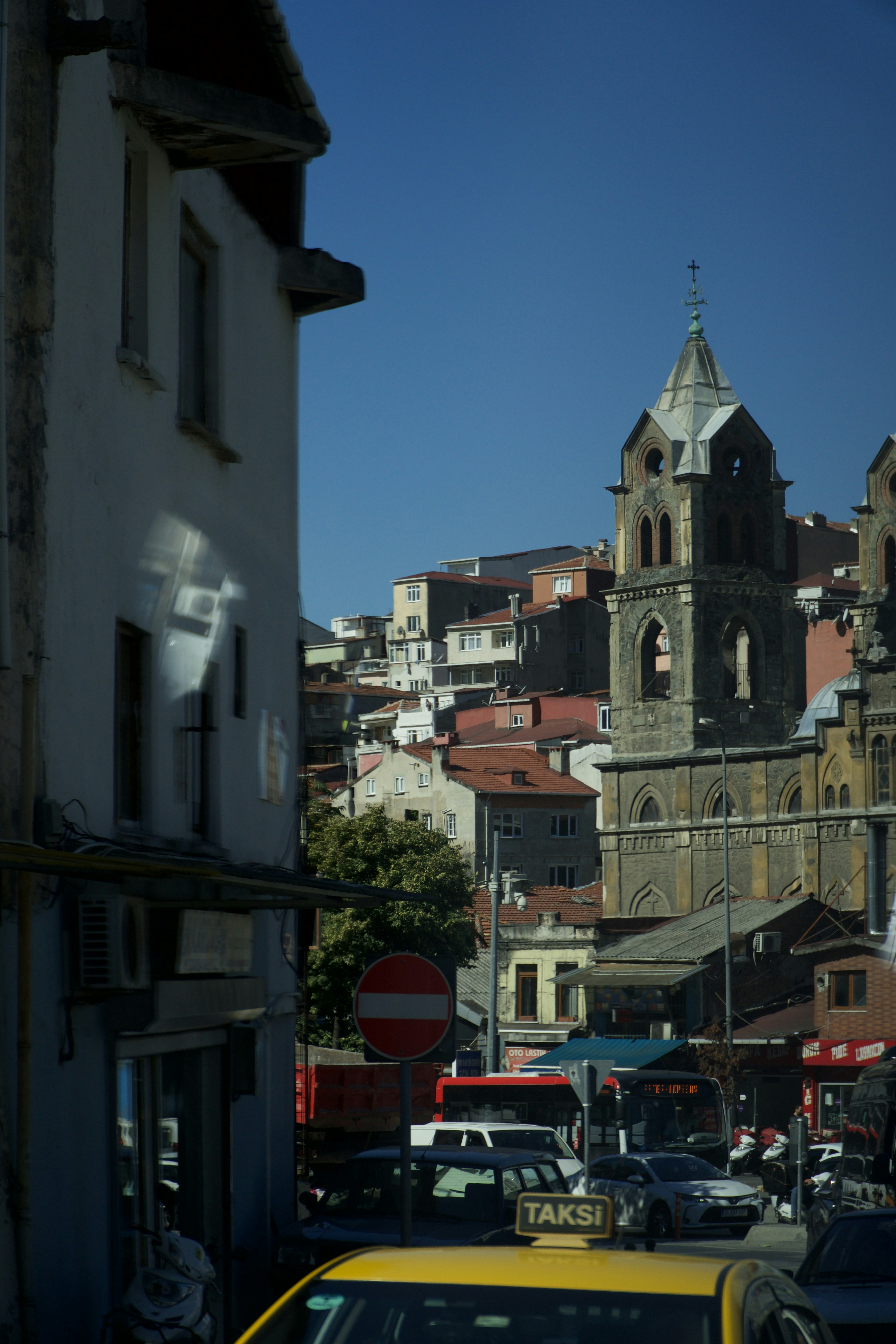 a yellow taxi driving down a street next to tall buildings