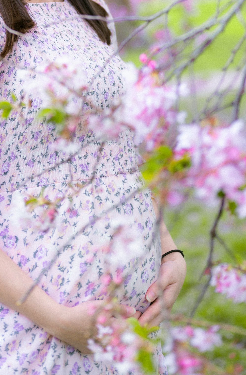 a pregnant woman standing in a field of flowers