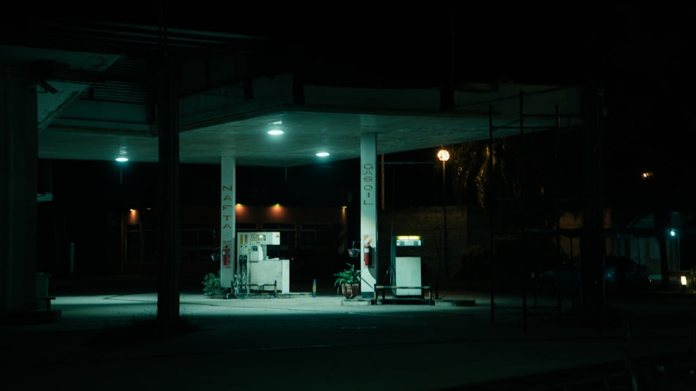 um posto de gasolina à noite com uma bomba de gasolina
