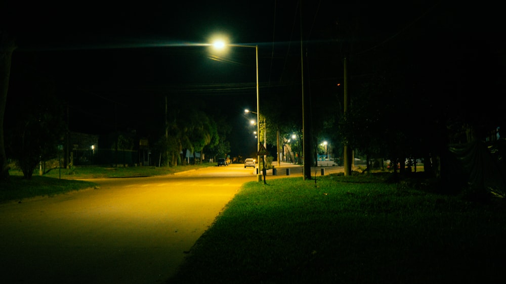a street at night with a street light in the distance