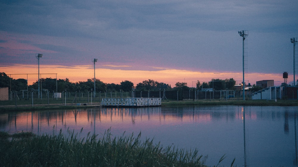 a large body of water sitting next to a lush green field