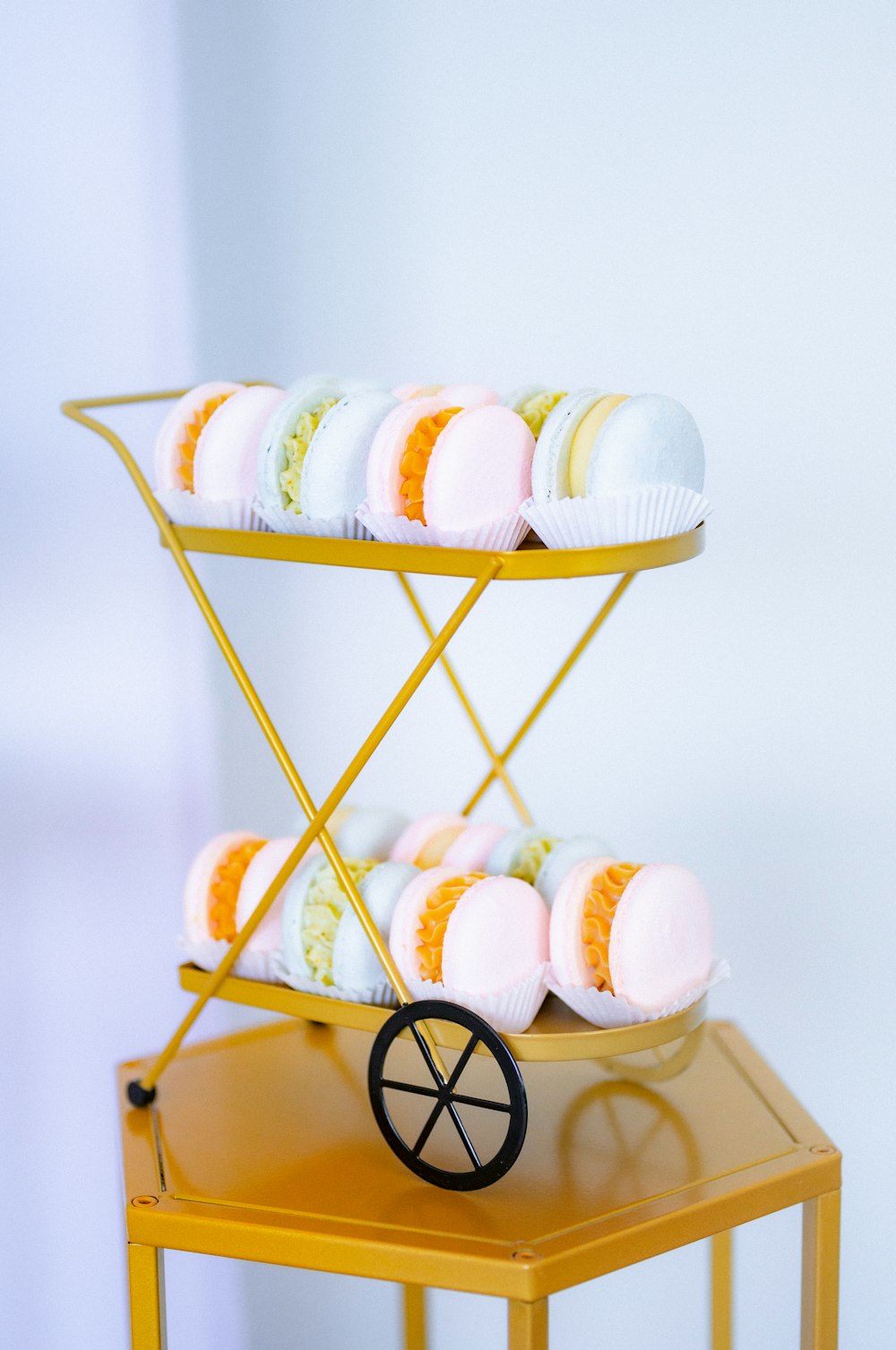 a cart filled with lots of cupcakes on top of a table